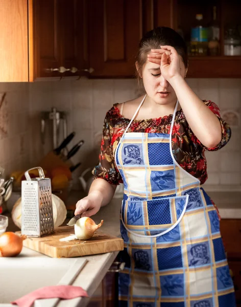 Домохозяйка плачет во время резки лука — стоковое фото