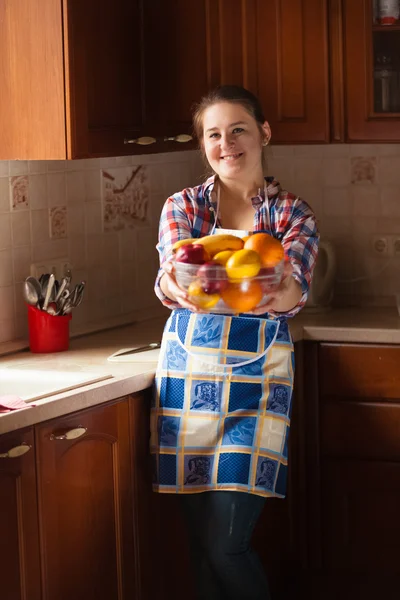 Usmívající se žena v domácnosti drží misku s ovocem — Stock fotografie