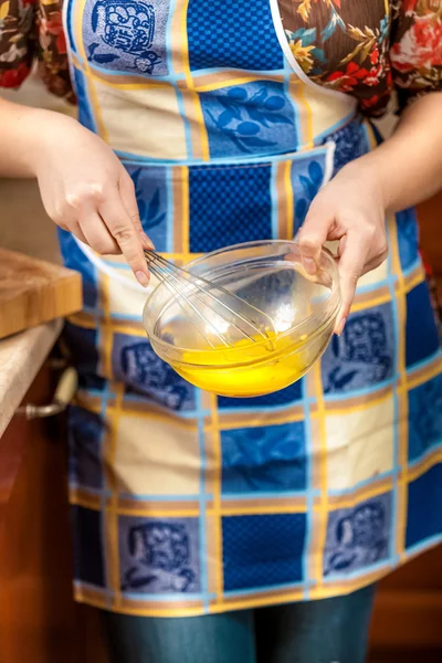 Foto de ama de casa batiendo la yema de huevo en un tazón de vidrio — Foto de Stock