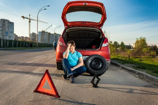 Depressed man leaning against broken car — Stock Photo, Image