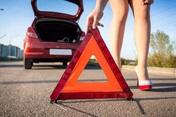 Photo of sexy woman putting warning sign on road — Stock Photo, Image