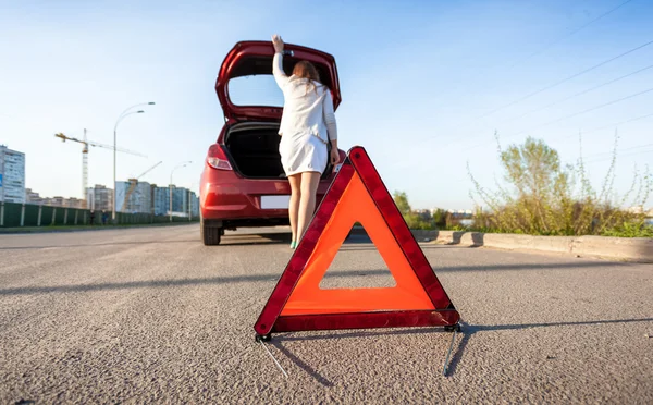 Mulher olhando na mala do carro quebrado — Fotografia de Stock