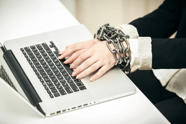 Photo of female hand chained up to laptop — Stock Photo, Image