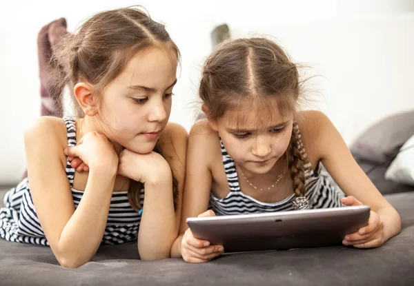 Concentrated young girls using digital tablet — Stock Photo, Image