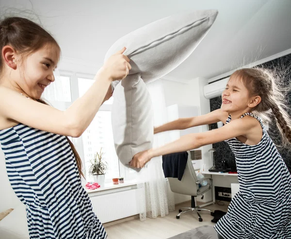 Portrait of two little sisters fighting with pillows — Stock Photo, Image