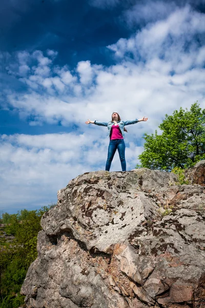 Beautiful woman standing on top of high cliff with stretched out — Stock Photo, Image