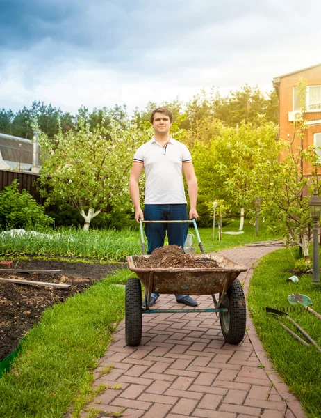 Mann mit Schubkarre im schönen Garten — Stockfoto