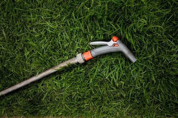 Foto van tuin hosepipe liggend op fris groen gras — Stockfoto