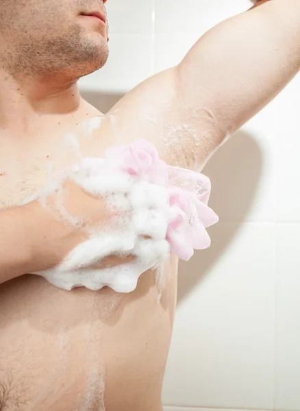 年轻男子洗胳肢窝用海绵的图片 — 图库照片