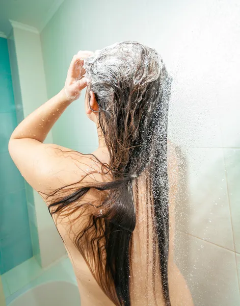 Foto de la mujer morena sexy espuma cabeza en la ducha — Foto de Stock