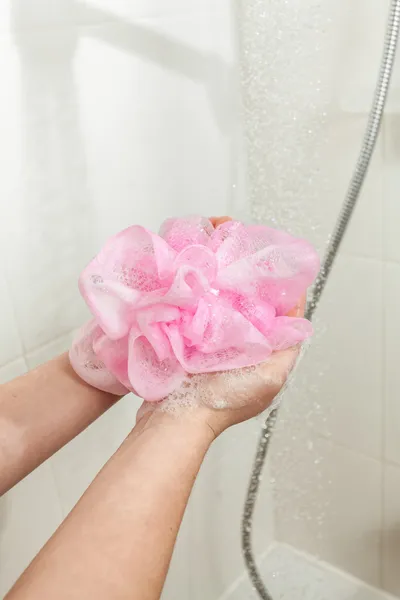 Foto de la mujer espuma esponja rosa en la ducha —  Fotos de Stock