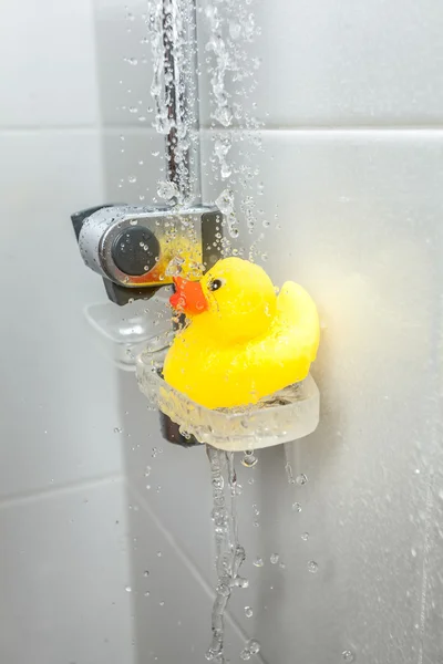 Foto de pato de borracha amarela no prato de sabão no chuveiro — Fotografia de Stock