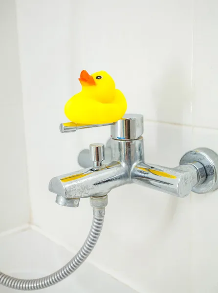 Pequeño pato de goma de pie en el grifo de la ducha —  Fotos de Stock