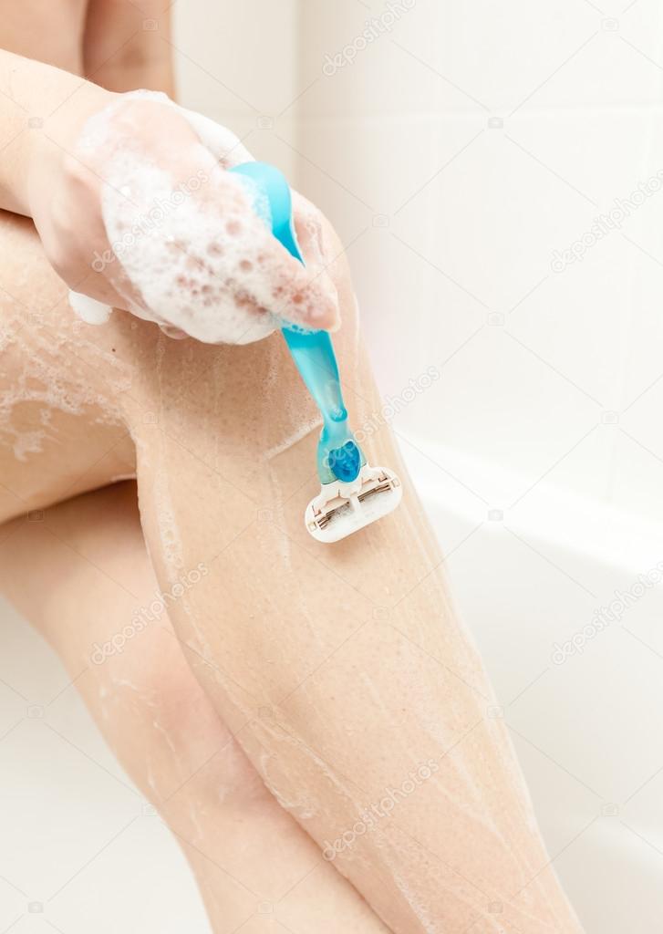 photo of woman shaving leg at bath