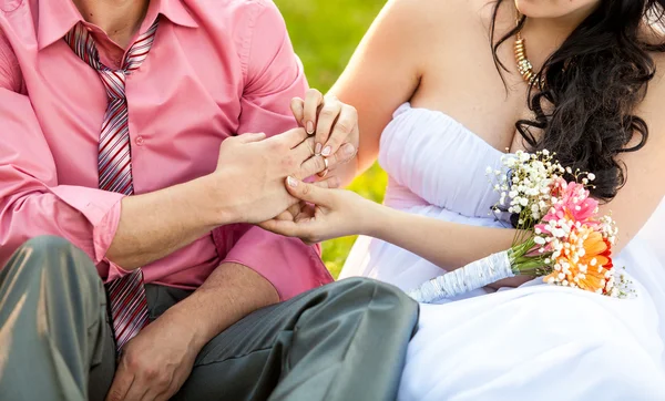 Foto de noiva jovem colocando anel de casamento na mão dos noivos — Fotografia de Stock