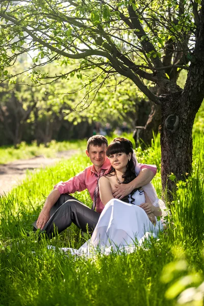 Novomanželé objímání pod stromem v alley — Stock fotografie