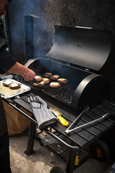 Man cooking marbled meat on barbecue for burgers — Stock Photo, Image