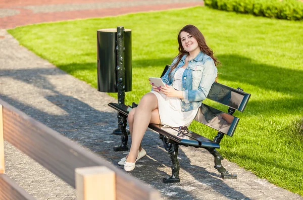 Женщина с табличкой на скамейке в парке — стоковое фото