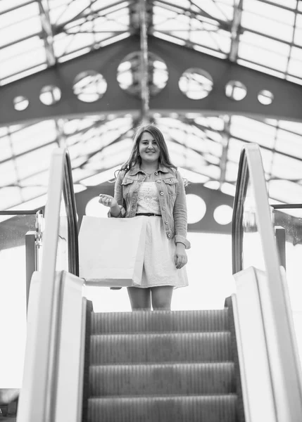 Monochrome Aufnahme einer Frau, die die Rolltreppe hinuntersteigt — Stockfoto