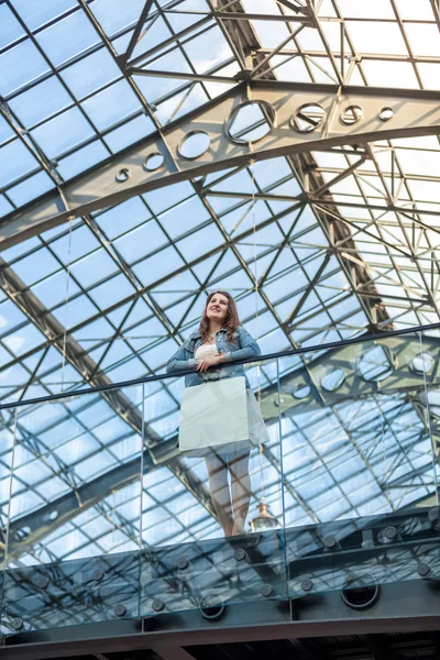 Woman standing on balcony at railway station with glass ceiling — Stock Photo, Image