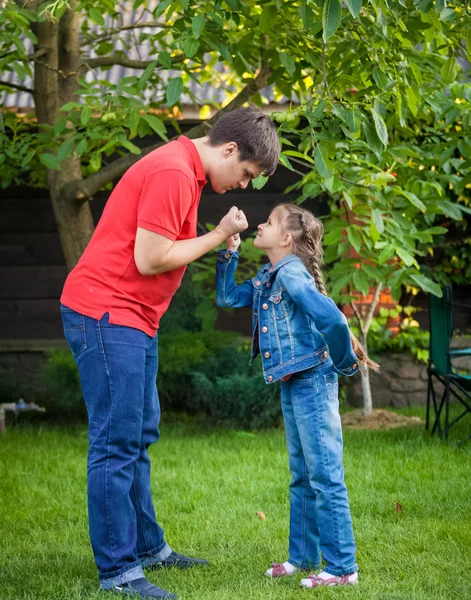 father and daughter looking at each other and holding fists