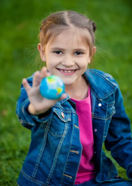 V ruce se usmívám dívka hospodářství zeměkoule — Stock fotografie