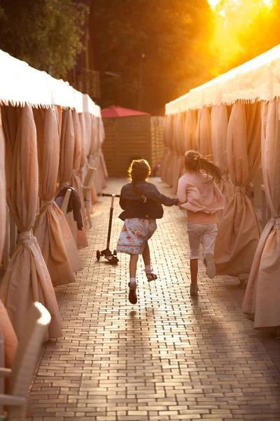 Little girls running on street at sunset — Stock Photo, Image