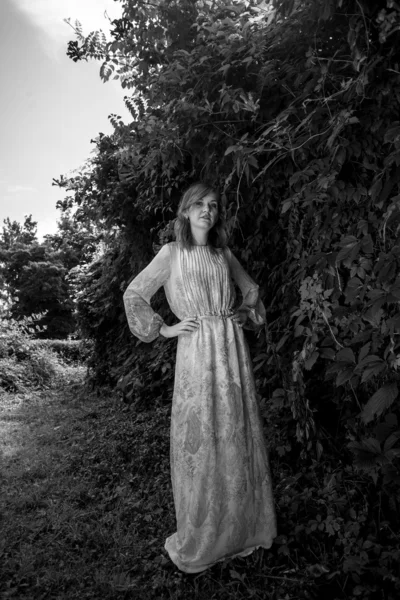 Monochrome photo of woman in long dress at forest — Stock Photo, Image