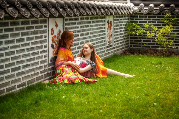 Two girls lying on grass at oriental park — Stock Photo, Image