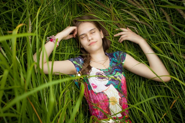 Retrato de bela menina bonita dormindo em grama alta — Fotografia de Stock