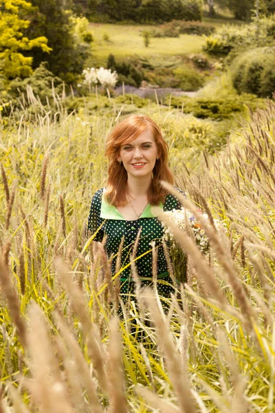 Smiling redhead girl walking at field — Stock Photo, Image