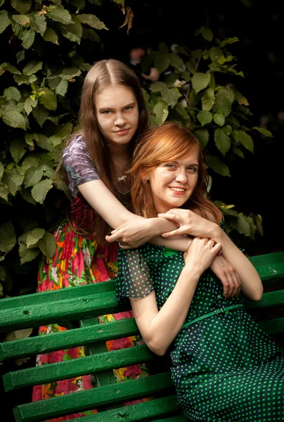 Dos hermanas en el banco en el parque — Foto de Stock