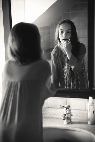 Monochrome portrait of small girl applying lipstick — Stock Photo, Image