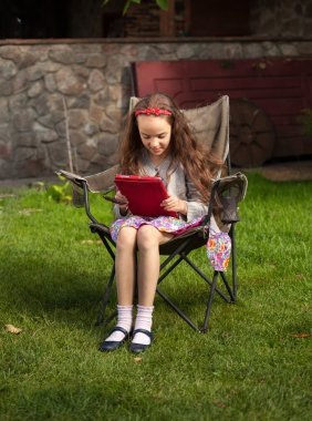 esmer kız Yard'da tablet kullanma마당에 태블릿을 사용 하 여 갈색 머리 소녀