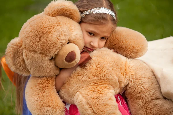 Foto gadis kecil yang sedih memeluk boneka beruang — Stok Foto