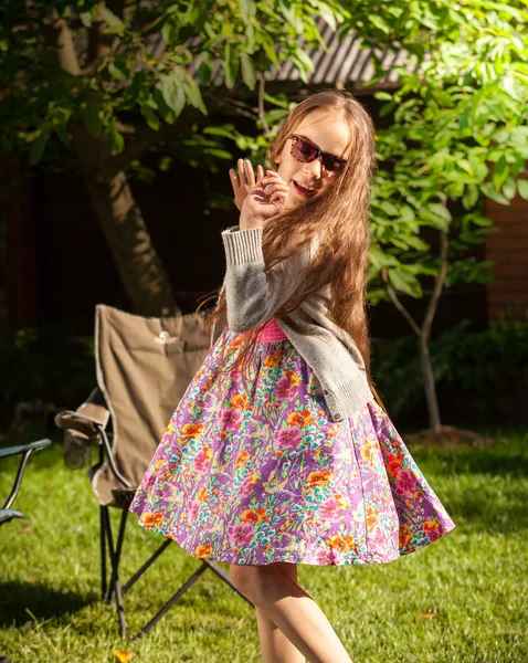 Young girl in sunglasses dancing at yard — Stock Photo, Image