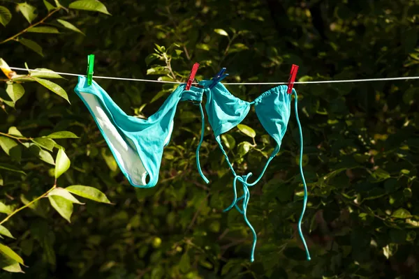 Vrouwelijke zwembroek drogen op waslijn op tuin — Stockfoto