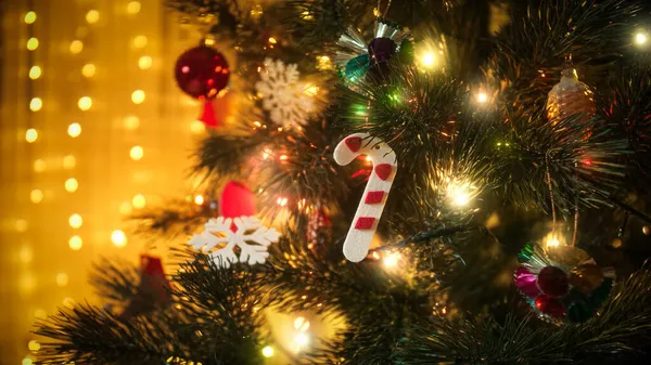 Closeup de árvore de Natal decorada e brilhante luz guirlanda colorida. Fundo para férias de inverno e celebrações — Fotografia de Stock