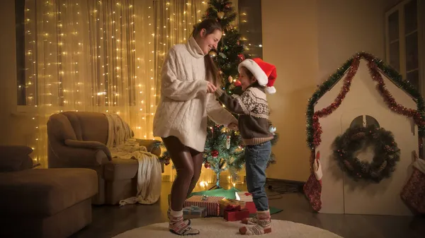 Skrattande pojke med mamma dansar på julfest hemma. Rena känslor hos familjer och barn som firar vinterlov. — Stockfoto