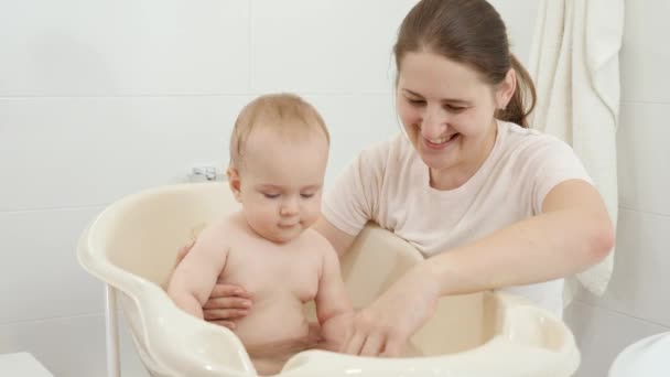 Bambino sorridente allegro con la madre che gioca mentre si lava nel bagno. Concetto di igiene dei bambini, assistenza sanitaria e genitorialità. — Video Stock