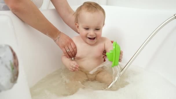 Buon bambino sorridente che si diverte a lavarsi nel bagno e giocare con i giocattoli. Concetto di igiene, assistenza sanitaria e sviluppo dei bambini a casa — Video Stock