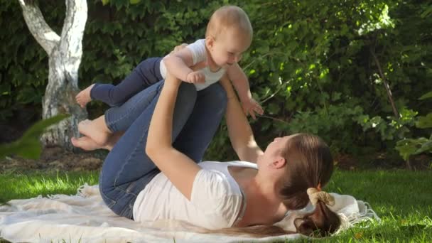 Boldog, vidám baba, anya játszik a füvön a parkban. Szülői, család, gyermekek fejlődését, és szórakoztató szabadban a természetben. — Stock videók