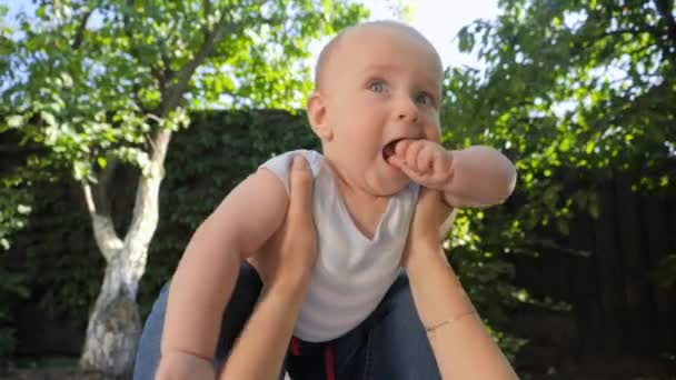 POV van ouder houden en tillen schattige baby zoon in de tuin. Ouderschap, familie, ontwikkeling van kinderen en plezier in de natuur. — Stockvideo