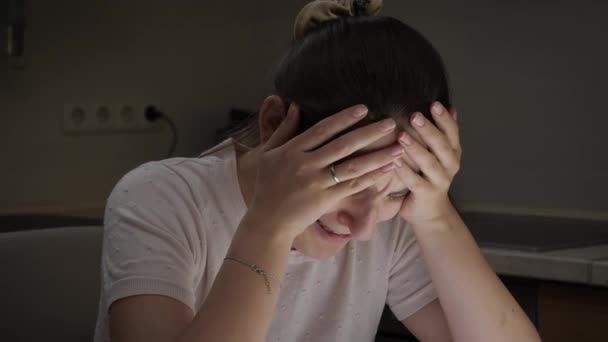 Retrato de mulher chorando desesperada sentada na cozinha à noite. Conceito de desespero, estresse, depressão, ansiedade e frustração. — Vídeo de Stock