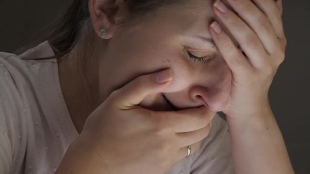 Nær en ensom staset kvinne som gråter og lukker munnen med hånden. Begrepene fortvilelse, stress, depresjon, angst og frustrasjon. – stockvideo