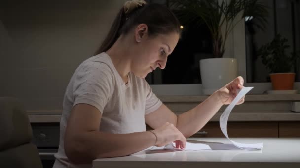 Mujer joven estresada que tiene problemas para sentarse por la noche leyendo documentos. Concepto de dificultades financieras, quiebra, impuestos y pago de alquileres. — Vídeos de Stock