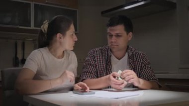 Stresli genç çift geceleri mutfakta aylık kredi veya kredi ödemesi hesaplıyor. Mali zorluklar, yoksulluk, iflas, vergiler ve kira ödemeleri kavramı.