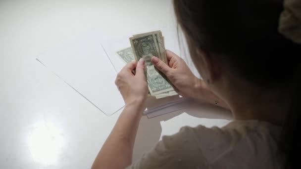 Mujer joven calculando el pago de impuestos y contando su poco dinero. Concepto de dificultades financieras, pobreza, quiebra, impuestos y pago de alquileres. — Vídeos de Stock