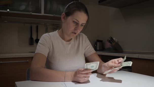 Mujer estresada acostada en la mesa después de contar su poco dinero y calcular los pagos mensuales. Concepto de dificultades financieras, pobreza, quiebra, impuestos y pago de alquileres. — Vídeos de Stock