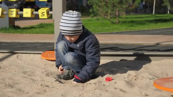 小さな男の子が砂丘の上で遊んで砂の城を建てる。子供の発達、スポーツ、教育の概念. — ストック動画
